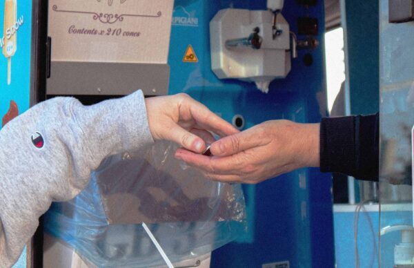 Cannabis customer exchanging products with a dispensary vendor